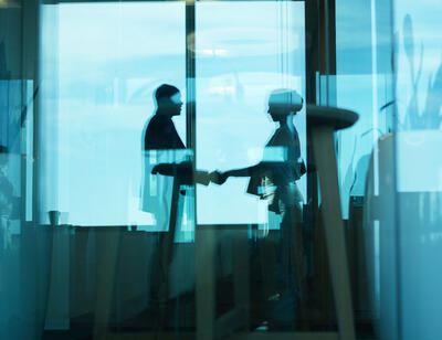 silhouette of a woman and a man shaking hands
