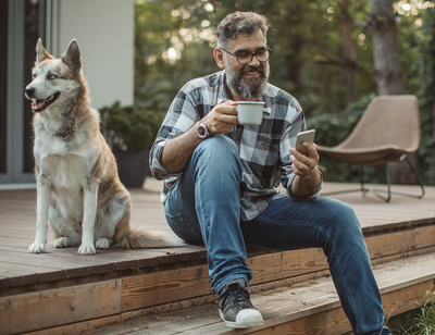 Man using phone with nearby dog